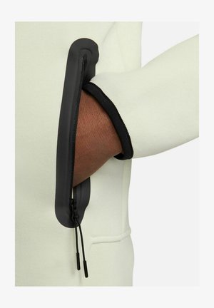 Felpa verde chiaro con tasca con cerniera. La tasca ha una cerniera nera e un bordo nero, caratterizzata da una texture liscia e un design moderno.