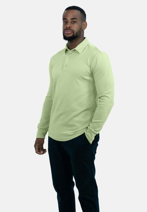 Lange mouw polo shirt in lichtgroene katoenmix, met een kraag en een placket met twee knopen, gecombineerd met donkerblauwe broek.