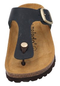 Sandalo thong in pelle nera con una fibbia metallica rotonda, una soletta in suede marrone e una suola scura e testurizzata. Presenta un supporto per le dita centrale.
