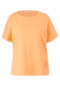 Orange cotton t-shirt with a round neckline, rolled sleeves, and a block logo detail on the lower left side. Soft, smooth texture.