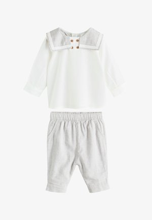 Maglietta bianca a maniche lunghe con colletto da marinaio grigio e bottoni di legno, abbinata a pantaloni grigio chiaro con vita elastica per un neonato o un bambino piccolo.