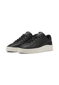 Zwarte leren sneakers met platte veters, een gestructureerde bovenkant en een dikke witte rubberen zool. Beschikt over een klein logo op de tong.
