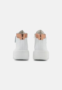 Bílé kotníkové boty s texturovaným měděným detailem na patě a silnou bílou podrážkou. Obsahují zadní zip pro zapínání.