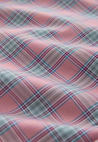 Miękka tkanina w kratę w kolorach różowym, jasnoniebieskim i fioletowym, z przecinającymi się liniami i kształtami diamentów.