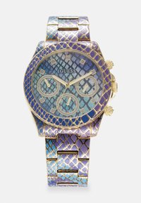 Montre chronographe avec un bracelet métallique multi-tonal en bleu et violet, motif à écailles texturées, accents dorés, et un cadran à motifs avec trois sous-cadrans.