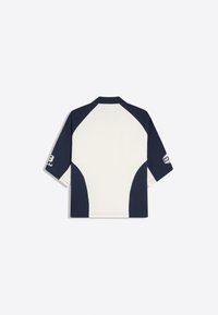 Chemise à manches courtes avec manches bleu marine et dos blanc, présentant des logos sur chaque manche, posée à plat avec le dos vers le haut.