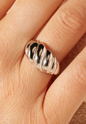 Sterling zilveren ring met gedraaid ontwerp, met afwisselend gepolijste en matte secties. Soepele textuur, afgeronde randen, gemiddelde breedte.