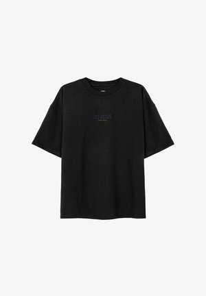 Czarny t-shirt z fioletowym napisem "THE SUNER THE BETTER", w zestawie z jaskrawozielonymi szortami. Materiał wydaje się miękki i casualowy.