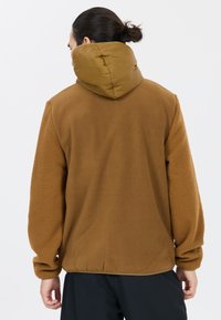 Kahvika fleece-takki, jossa on kontrastina oliivinvihreä puffahuppu. Takissa on teksturoitu pinta ja rento istuvuus, sekä elastiset hihansuut ja helma.