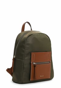 Sac à dos vert olive avec une forme arrondie, des accents en cuir marron, une poche zippée à l'avant et des éléments en métal argenté. Texture lisse et design robuste.