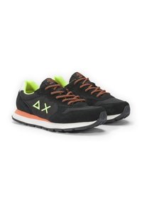 Scarpe da ginnastica nere con accenti verde lime, lacci arancioni, materiali in suede e mesh, con una suola intermedia bianca e una suola esterna in gomma testurizzata.