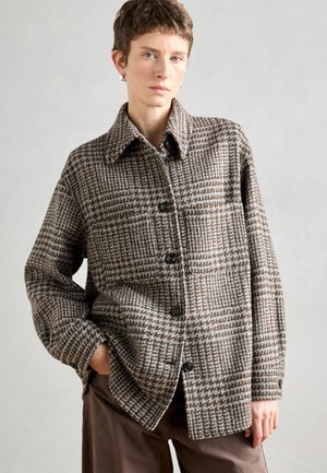 Brun og beige ternet jakke lavet af tekstureret stof, med spids krave, knaplukning og en brystlomme.