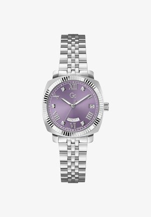 Hõbedane roostevabast terasest kell, millel on ristkülikuline lillakate kellaplaat, Rooma numbrid, teemantaktsendid ja link-riba. Omab kuupäeva näidikut.