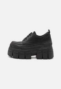 Black platform sneakers with a smooth leather upper, lace closure, thick rubber sole, and branding detail on the side.
