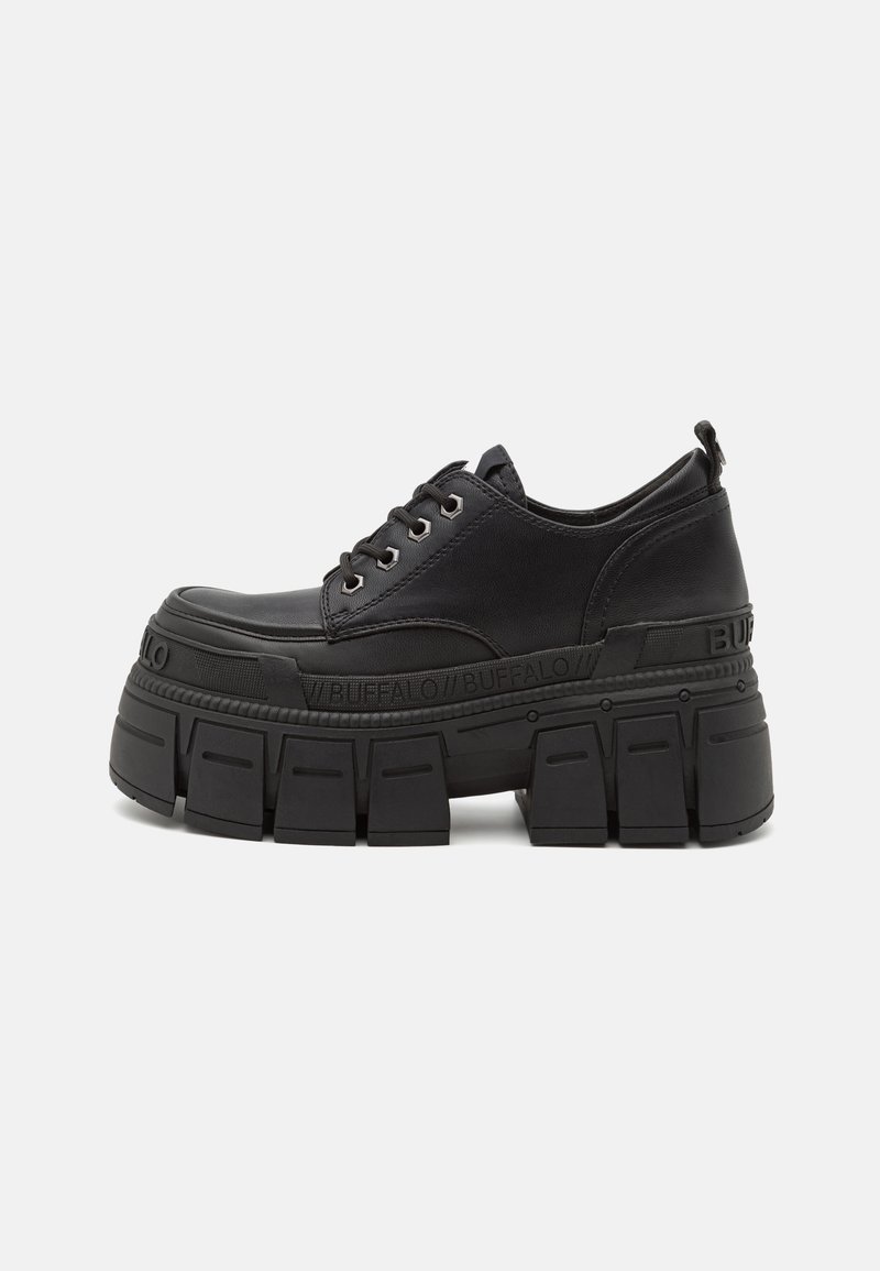 Black platform sneakers with a smooth leather upper, lace closure, thick rubber sole, and branding detail on the side.