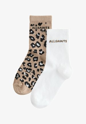 Paar Crew-Socken, ein beiges mit schwarzem und weißem Leopardenmuster, das andere schlicht weiß; beide mit dem Schriftzug "ALLSAINTS" nahe der Bündchen versehen.
