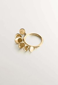 Anillo de oro con múltiples colgantes circulares de diferentes tamaños, con textura lisa y un acabado brillante. Diseño simple con una estética moderna.