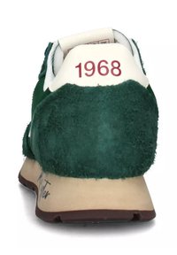 Sneaker retro verde in suede con linguetta e tallone bianchi, con l'anno "1968" stampato in bordeaux sul retro e una suola beige.
