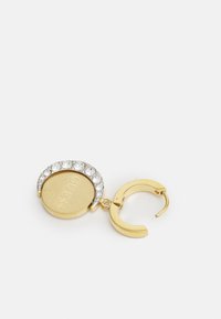 Boucle d'oreille en métal doré avec un pendentif circulaire, doté d'un sommet orné de cristaux et d'un logo gravé. Fermoir articulé pour la fermeture.