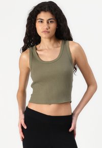 Khaki žebrovaný crop top s širokým výstřihem a bezrukávovým designem, kombinovaný s černými vysokými kalhotami, hladká textura.