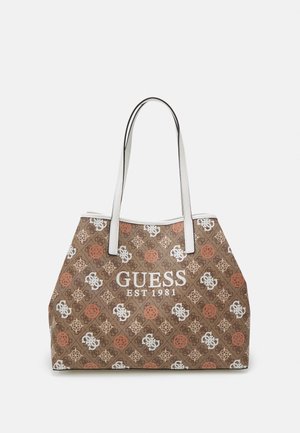 Brązowa torba typu tote z białymi uchwytami, ozdobiona wielokolorowymi logo Guess oraz napisem "GUESS EST 1981" na przedzie.