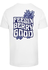 Balta marškinėliai su tamsiai mėlyna grafika, kurioje yra tekstas "FEELIN BERRY GOOD" ir mėlynių bei lapų iliustracija.
