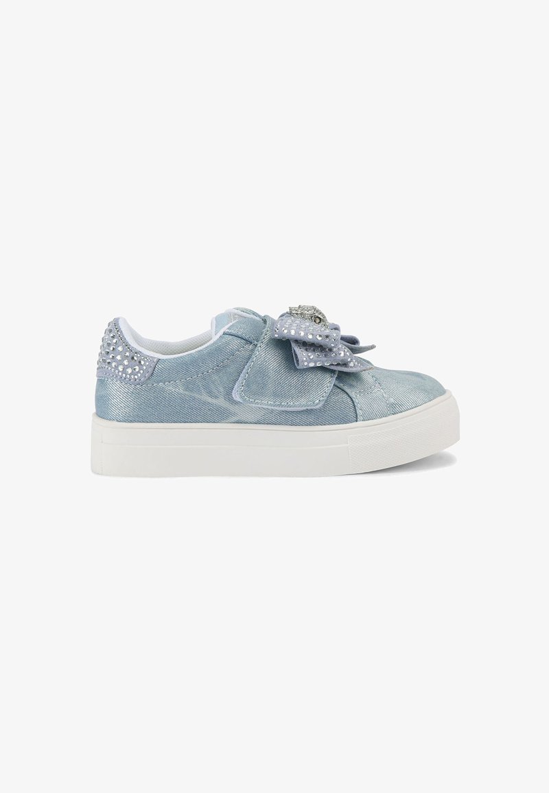 Sneakers en denim bleu clair avec une semelle blanche, ornées d'un nœud décoratif, d'accents argentés et de clous en forme de cristal sur le talon.