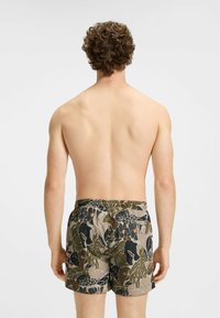 Maillots de bain à motif floral, avec des couleurs vertes, brunes et oranges. Taille élastique, longueur au-dessus du genou, matériau léger.