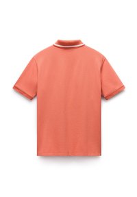 Lyhythihainen korallinvärinen polo-paita, jossa on pehmeä tekstuuri, ribattu kaulus ja valkoinen raita kaulan ympärillä. Ei kuvioita tai grafiikoita.