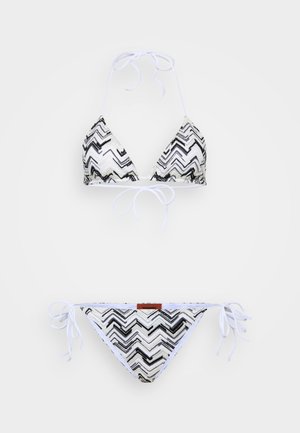 Bikiny set s černobílým zigzagovým vzorem, trojúhelníkový vršek s šňůrkami na zavazování a odpovídající kalhotky se bočními šňůrkami.