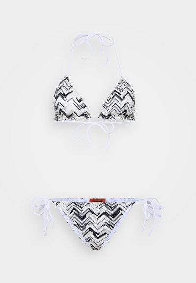 Conjunto de biquíni com um padrão em zigzag preto e branco, parte de cima triangular com cordões para amarrar e parte de baixo correspondente com laços laterais.