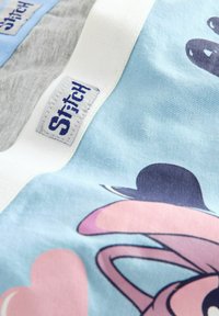 Tissu bleu clair mettant en avant une illustration graphique avec des accents roses. Bande élastique blanche avec des coutures bleues étiquetée "Stitch". Texture lisse.