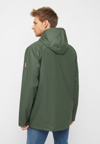 Giacca impermeabile verde con cappuccio, caratterizzata da un taglio dritto, una texture liscia e un piccolo logo sul maniche.