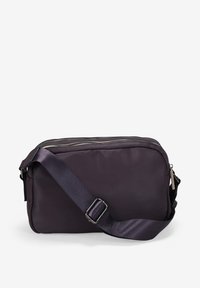 Bolso de hombro de color púrpura oscuro, hecho de tela suave, con cierre de cremallera, correa ajustable y forma rectangular con un diseño minimalista.