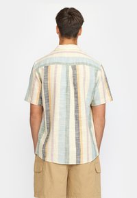 Short-sleeved shirt featuring vertical multicolored stripes in beige, blue, and gray. Fabric has a textured finish with a back yoke detail.