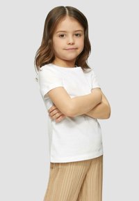 Witte katoenen t-shirt met korte mouwen, voorzien van een ronde halslijn, gecombineerd met lichtbeige geplooide broek. Eenvoudig, casual ontwerp.