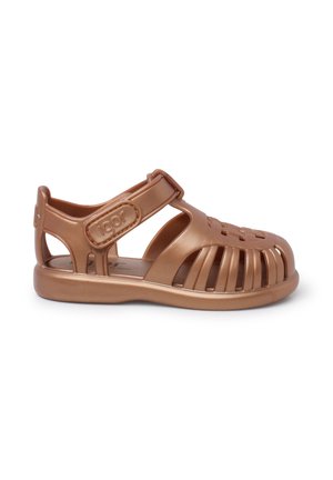 Brun plastik sandal med dækket tå og åbne sider, der har en rem med spænde. Tekstureret gummisål med ventilationshuller.
