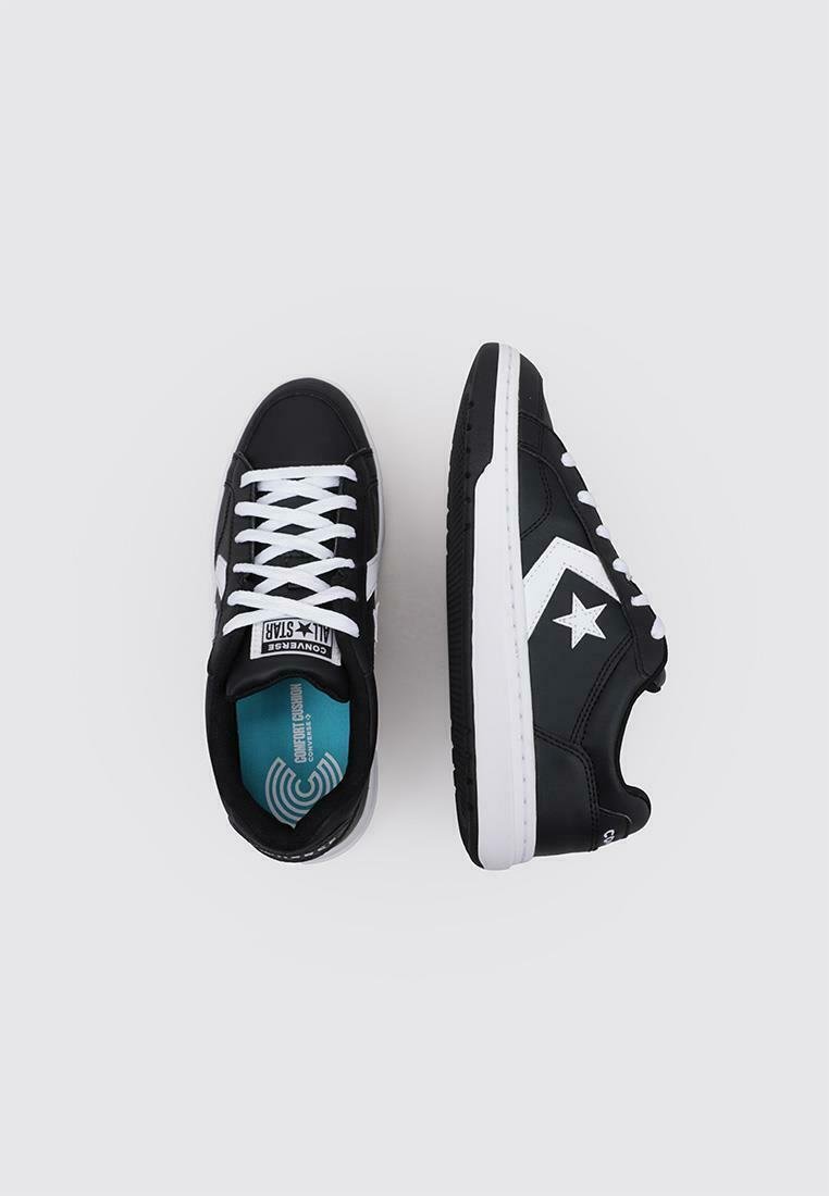 Baskets noires avec accents blancs, présentant un dessus en simili cuir, une semelle en caoutchouc et un design classique à lacets. L'intérieur dispose d'une semelle intérieure bleu clair.