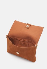 Brun suedette clutch taske med en tekstureret overflade, udstyret med en magnetisk tryklukning og et beige stofinteriør med et mærke.