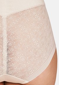 Lace brief in soft beige with intricate floral pattern, elastic waistband, and smooth texture. Features slight sheen and breathable design.