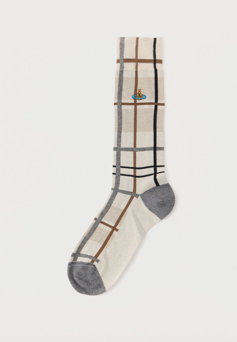 Κρέμ κάλτσα με γκρι φτέρνα και μύτη, διακοσμημένη με καφέ, μαύρες και γκρι γραμμές καρό και ένα μικρό πολύχρωμο έμβλημα σφαίρας κοντά στον καρπό.