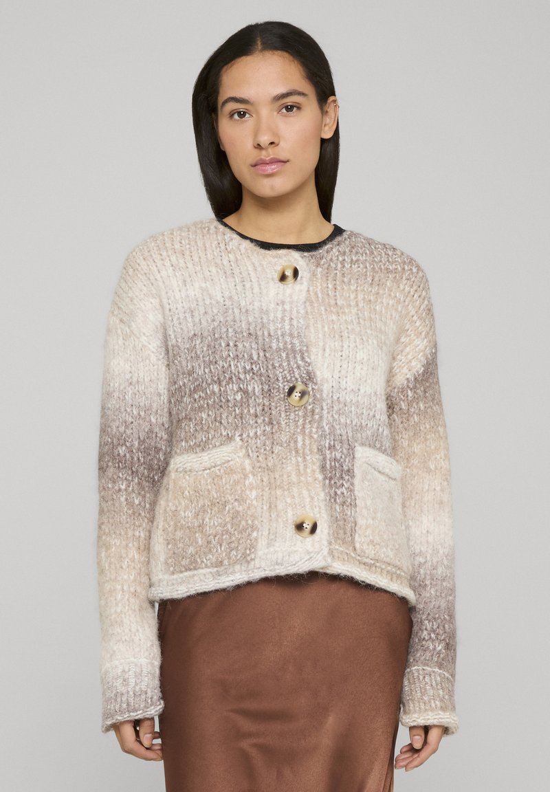 Cardigan tricoté en dégradé beige et marron avec de gros boutons dorés et des poches avant. Tissu texturé avec une coupe décontractée et manches longues.