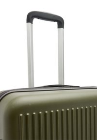 Twarda walizka w oliwkowym kolorze z teksturowaną powierzchnią i pionowymi żłobieniami. Posiada chowany szary uchwyt oraz zamknięcie na zamek błyskawiczny.