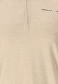Beige kwart-rits pullover gemaakt van zacht, textuurmateriaal. Voorzien van een rits met een rechthoekige trekker en geborduurd "ENDURANCE" logo.