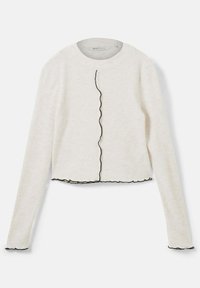 Jasno beżowy, prążkowany crop top z długim rękawem, okrągłym dekoltem oraz czarną falistą lamówką wzdłuż przedniego otwarcia i dolnego brzegu.