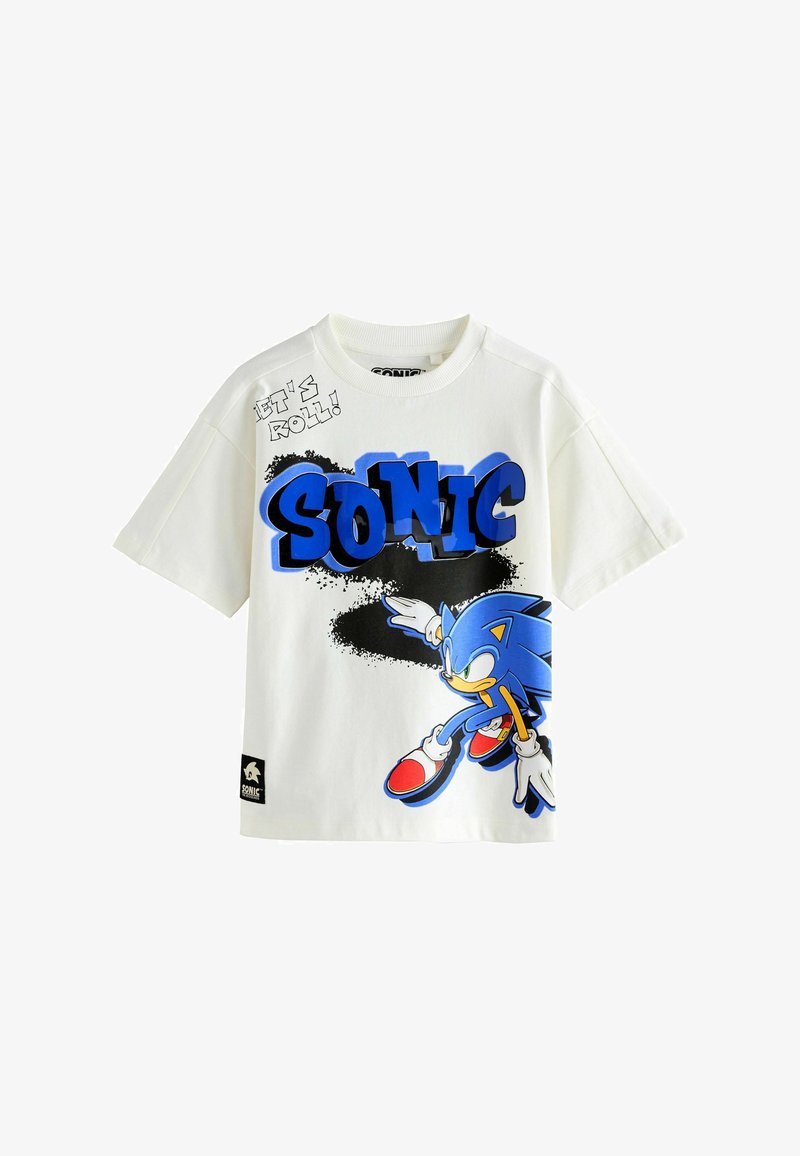 T-shirt blanc à manches courtes avec texte bleu « SONIC », éclaboussure de peinture noire, et personnage de Sonic le Hérisson en position de course sur le devant.