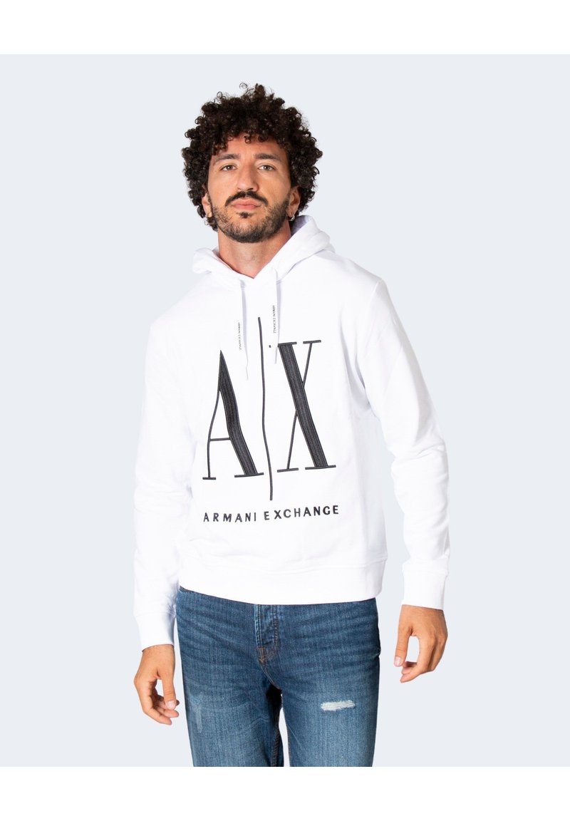 Felpa bianca con cappuccio e logo nero "AX" e testo "ARMANI EXCHANGE", dotata di cappuccio con cordino e polsini a costine. Indossata con jeans blu.