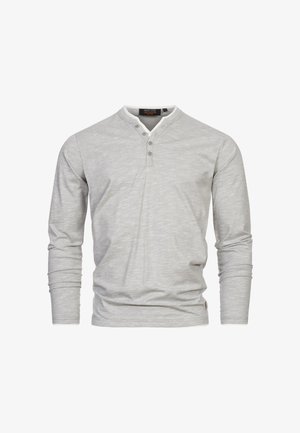 Cămașă gri cu mânecă lungă și guler rotund, având un guler interior alb și trei nasturi la gât. Textură netedă, design simplu.