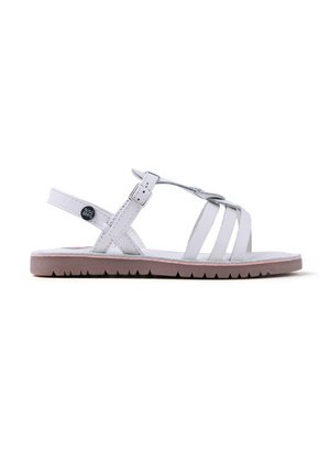 Sandalia blanca de cuero con correas cruzadas, hebilla ajustable, suela de goma plana y una banda de rodadura rosa texturizada. Presenta un adorno con un logotipo redondo.