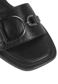 Black leather slide sandal with a square toe and wide strap. Features a metallic buckle detail for adjustment. Smooth texture throughout.